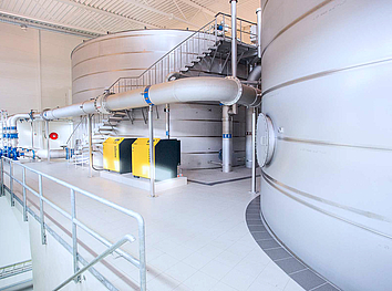Industrielle UV-Desinfektionsanlagen aus Edelstahl mit elektrischen Steuerungskästen in einer Produktionsumgebung.