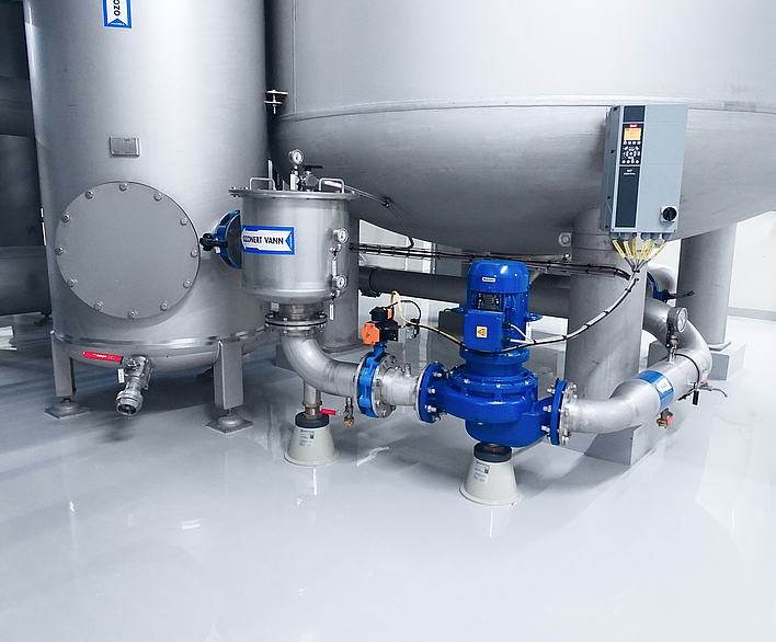 Mehrstufige vertikale Kreiselpumpen in Blau an einer Edelstahlrohrleitung mit höhenverstellbaren Rohrstützen in einer Industrieanlage.